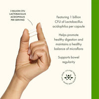 Hand holding a capsule with lactobacillus acidophilus information on a white background