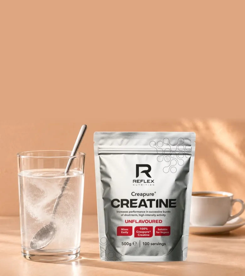 Reflex Nutrition Creapure creatine powder, 500g pouch, beside a glass of water, stocked in Dublin